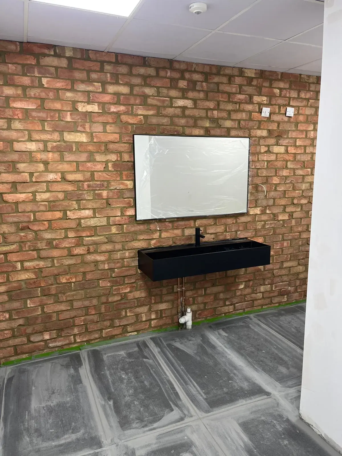 Bathroom prepared for final plumbing fittings and finishes