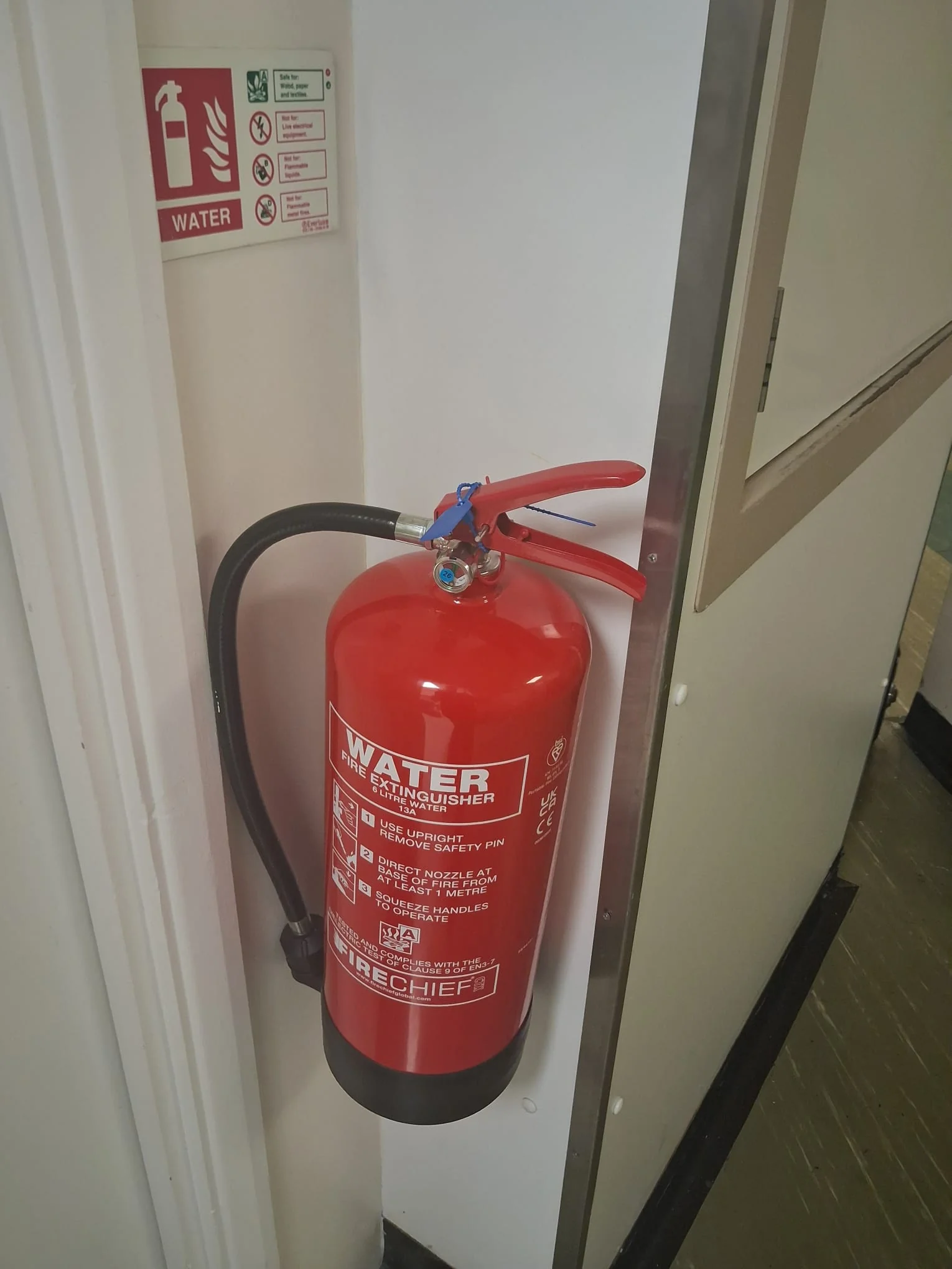 Wall-mounted fire extinguisher inspected in commercial premises