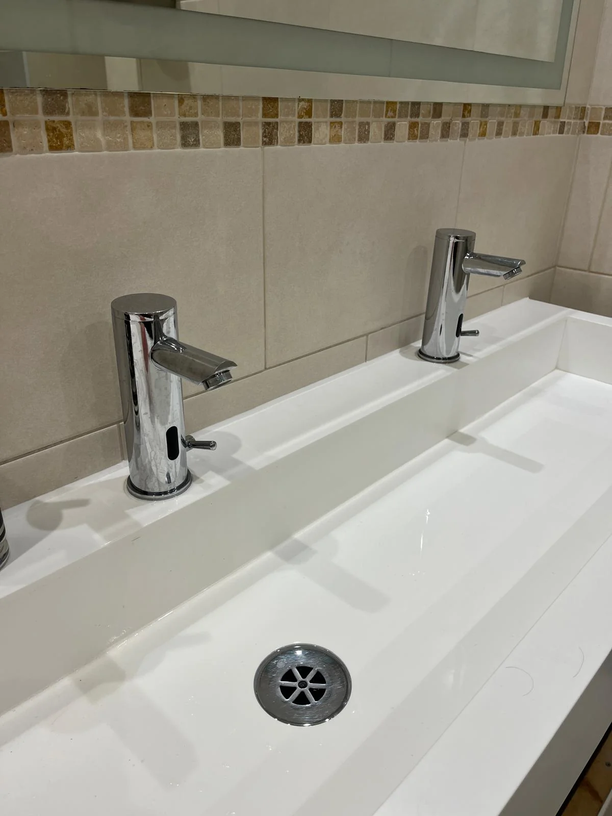Basin supply and waste connections being installed in a commercial washroom