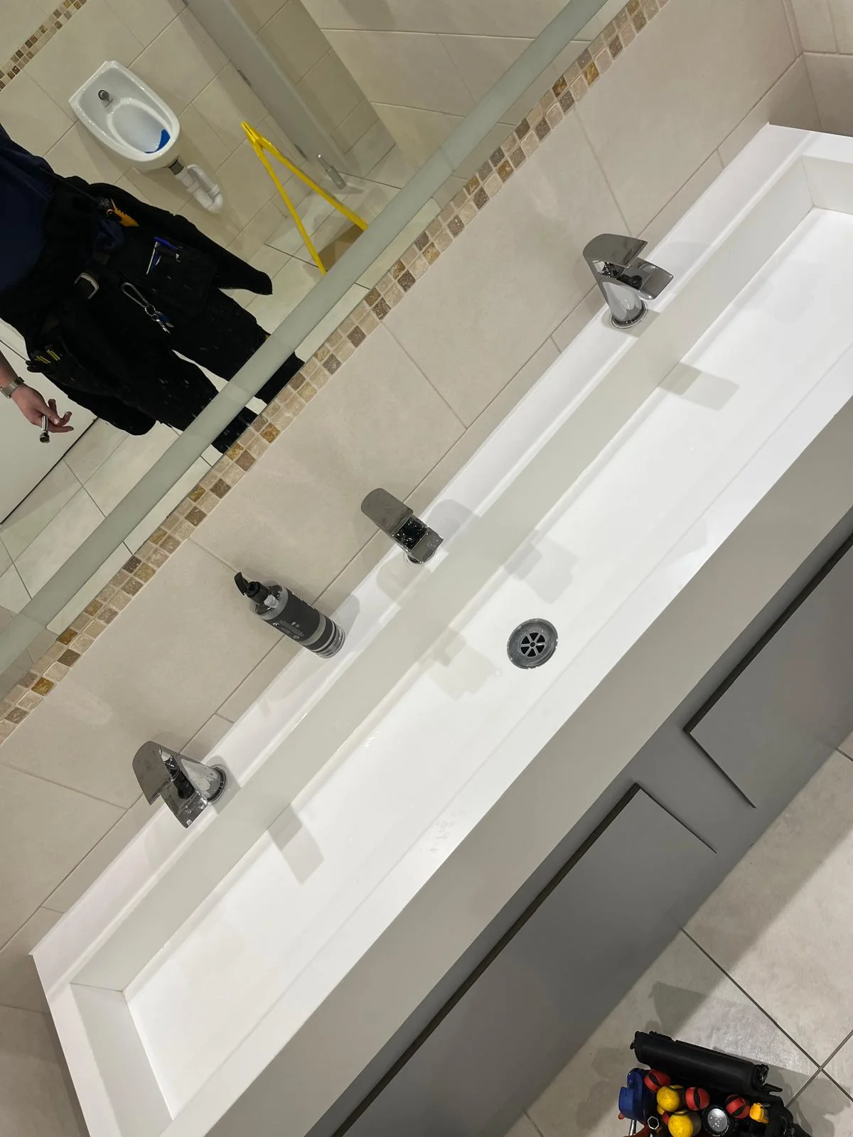 Final tap and waste fittings installed on a commercial washroom basin