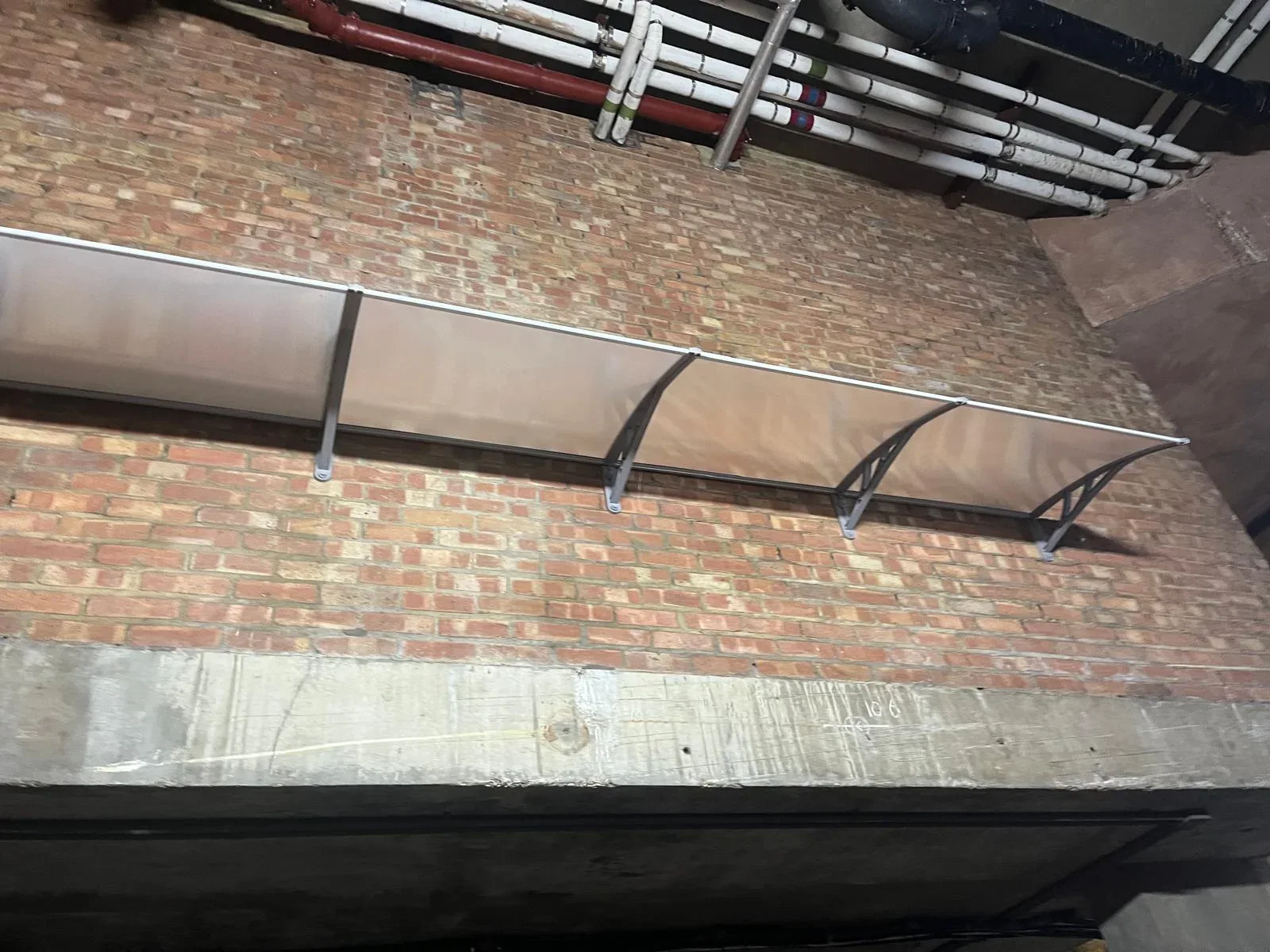 Outdoor canopy framework installed beside a brick building