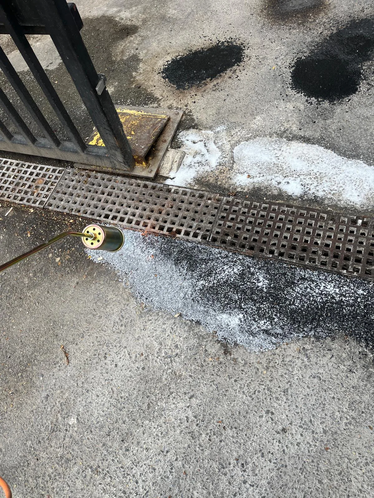 Propane torch heating tarmac during external surface repair